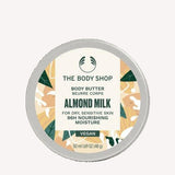 The Body Shop Almond Milk body butter container on a beige background