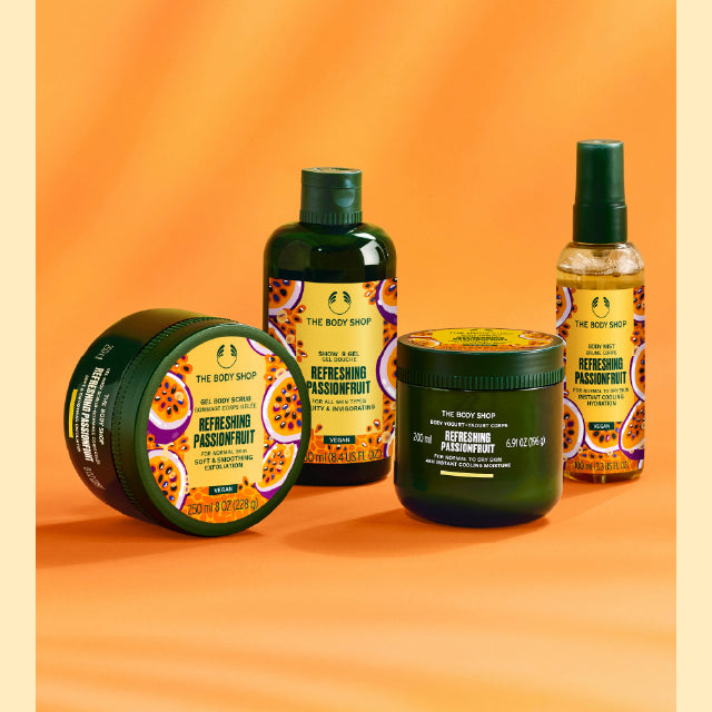 Collection of The Body Shop's Refreshing Passionfruit products on orange background