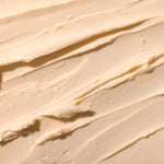 Close-up of The Body Shop's smooth, orange-y pink Sugar Pumpkin body butter spread out