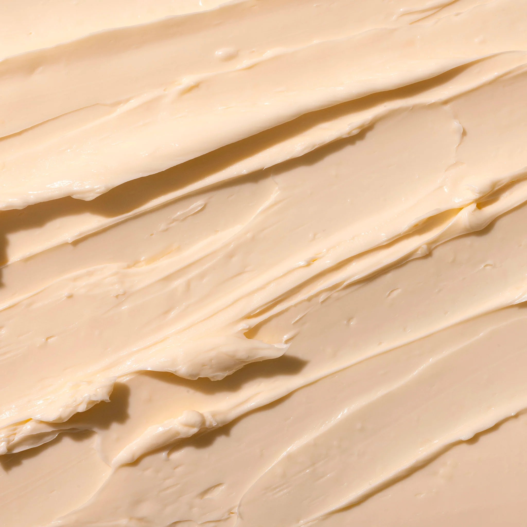 Close-up of The Body Shop's smooth, orange-y pink Sugar Pumpkin body butter spread out